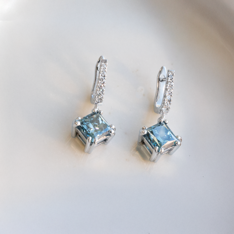 huggie earrings with a blue diamond drop. hand crafted by our master jewellers in our workshop in auckland, new zealand