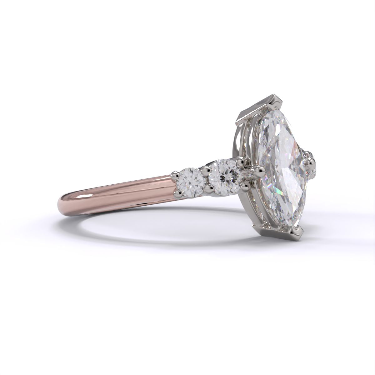 A marquise-cut diamond engagement ring with two round brilliant-cut diamonds on either side, set in platinum on a rose gold band.