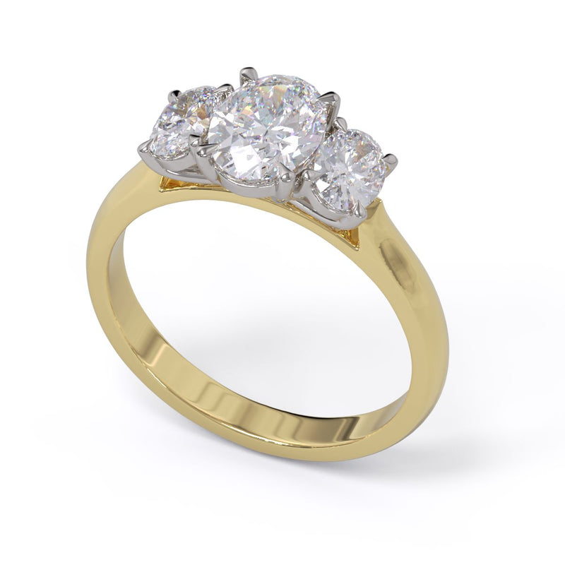 A three stone diamond engagement ring with oval diamonds set in platinum on a yellow gold band.