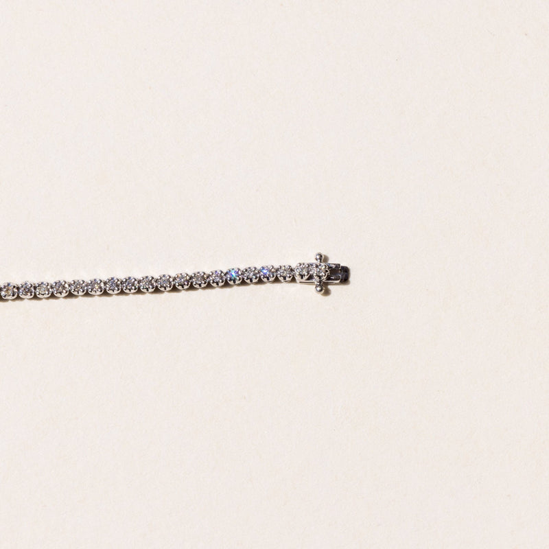 close up of the clasp on A tennis bracelet, adorned with round brilliant cut diamonds.