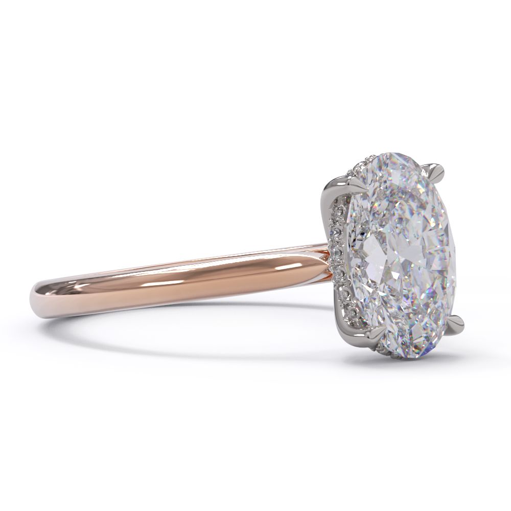 An oval solitare engagement ring with a halo of round pave diamond. Set in a platinum setting on a rose gold or platinum band.