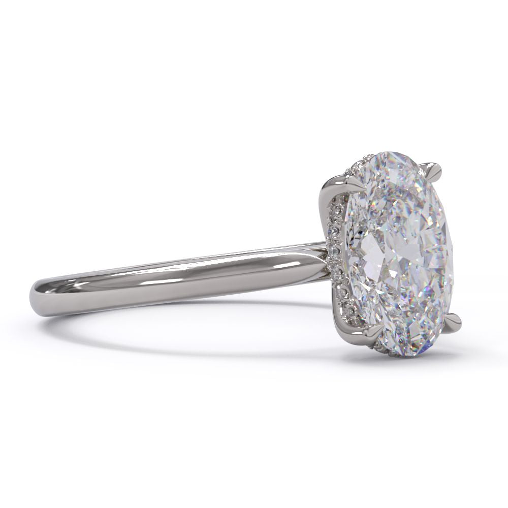 An oval solitare engagement ring with a halo of round pave diamond. Set in a platinum setting on a white gold or platinum band.