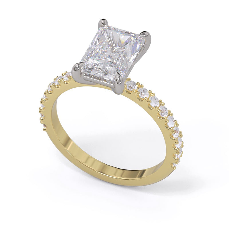 A radiant cut diamond solitaire ring with a diamond pave band, set in a claw setting in platinum on a yellow gold band.