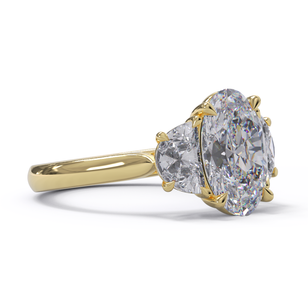 An exquisite white diamond engagement ring with an oval centerpiece flanked by two half moon diamonds, set in a yellow gold band