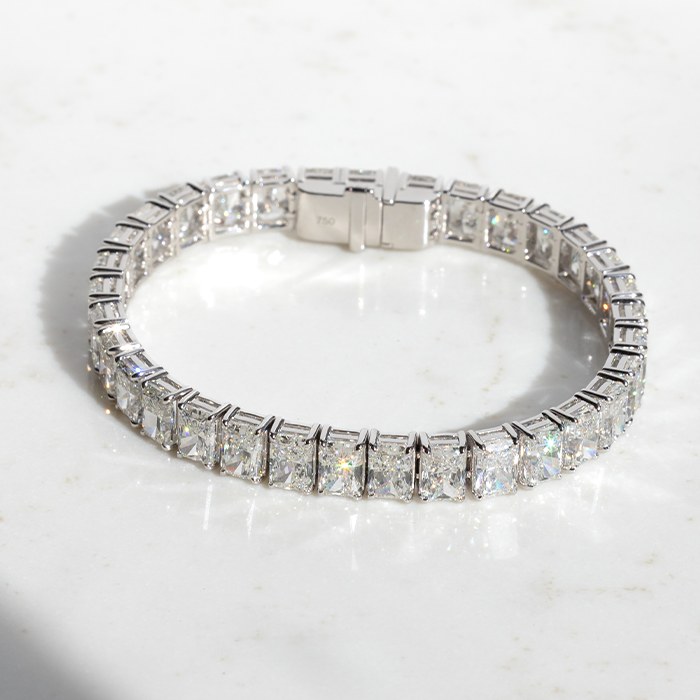 A large diamond tennis bracelet featuring a series of brilliant cut diamonds, set in a white gold band.