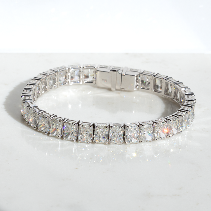 A tennis bracelet featuring a series of brilliant cut diamonds, set in a white gold band.