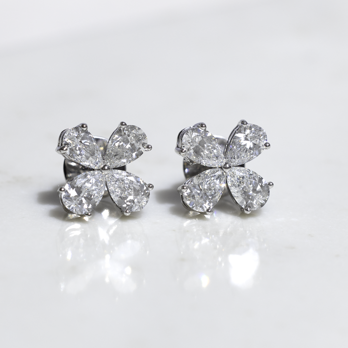 earrings with four pear shaped diamonds that make a flower shape.