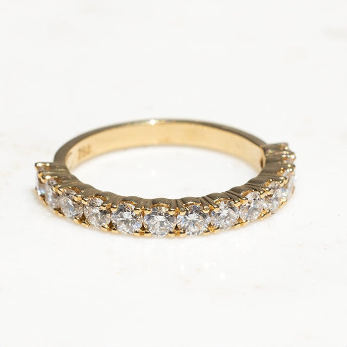 An 18k yellow gold eternity ring featuring lab-created round brilliant diamonds