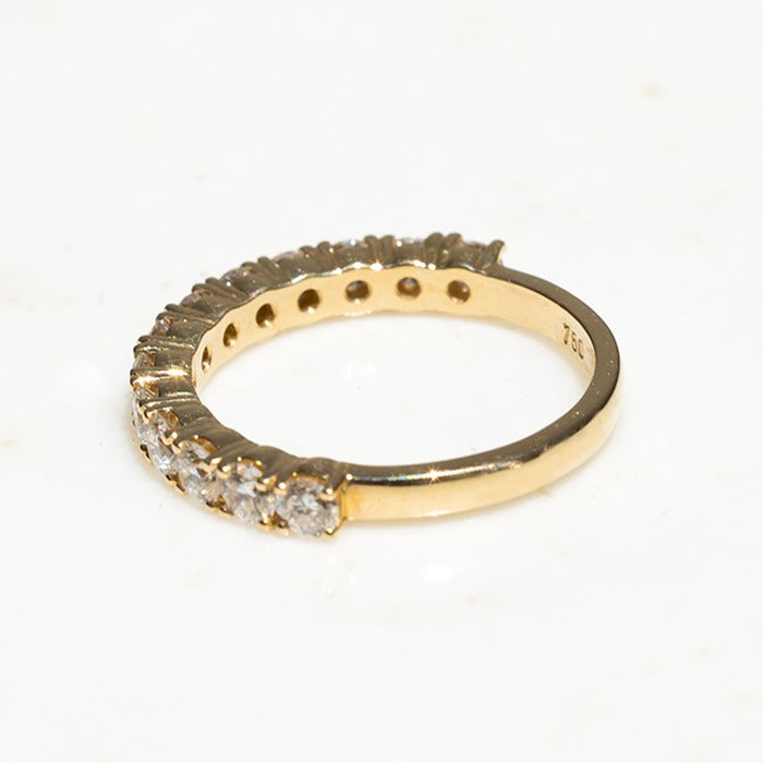 An 18k yellow gold eternity ring featuring lab-created round brilliant diamonds
