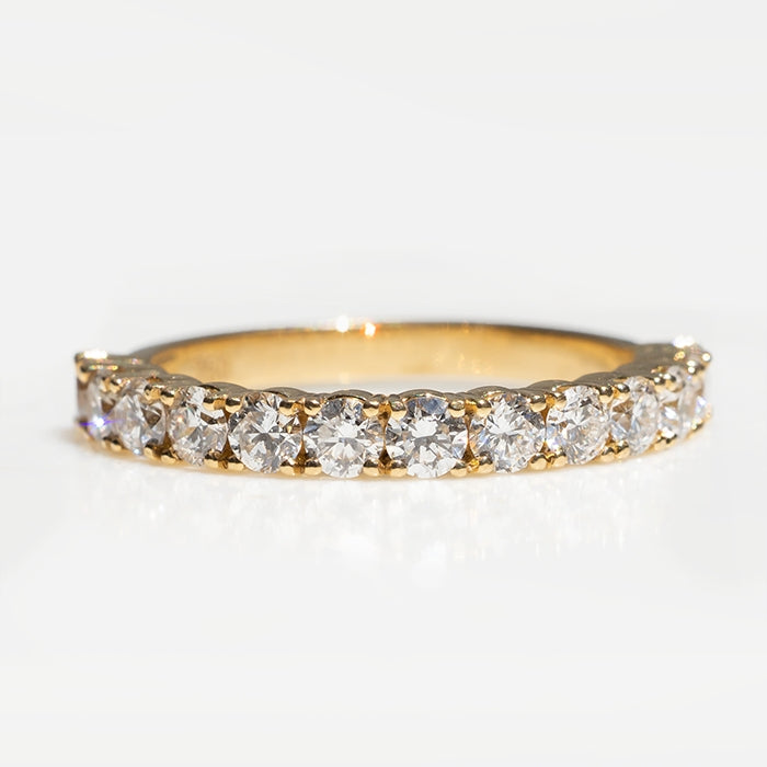 An 18k yellow gold eternity ring featuring lab-created round brilliant diamonds