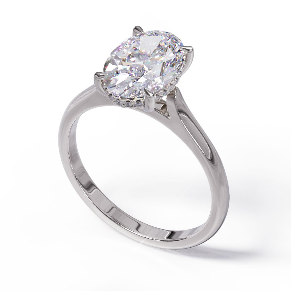 An oval solitare engagement ring with a halo of round pave diamond. Set in a platinum setting on a white gold or platinum band.