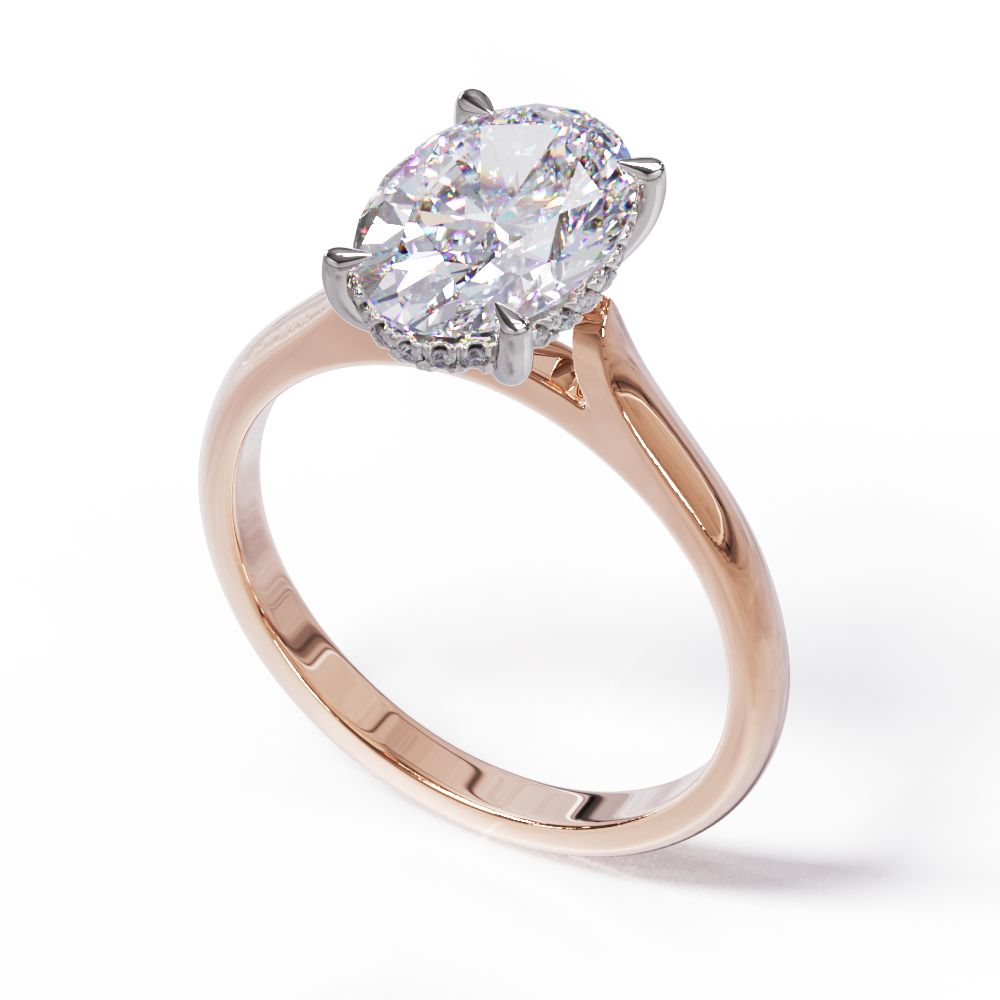 An oval solitare engagement ring with a halo of round pave diamond. Set in a platinum setting on a rose gold or platinum band.