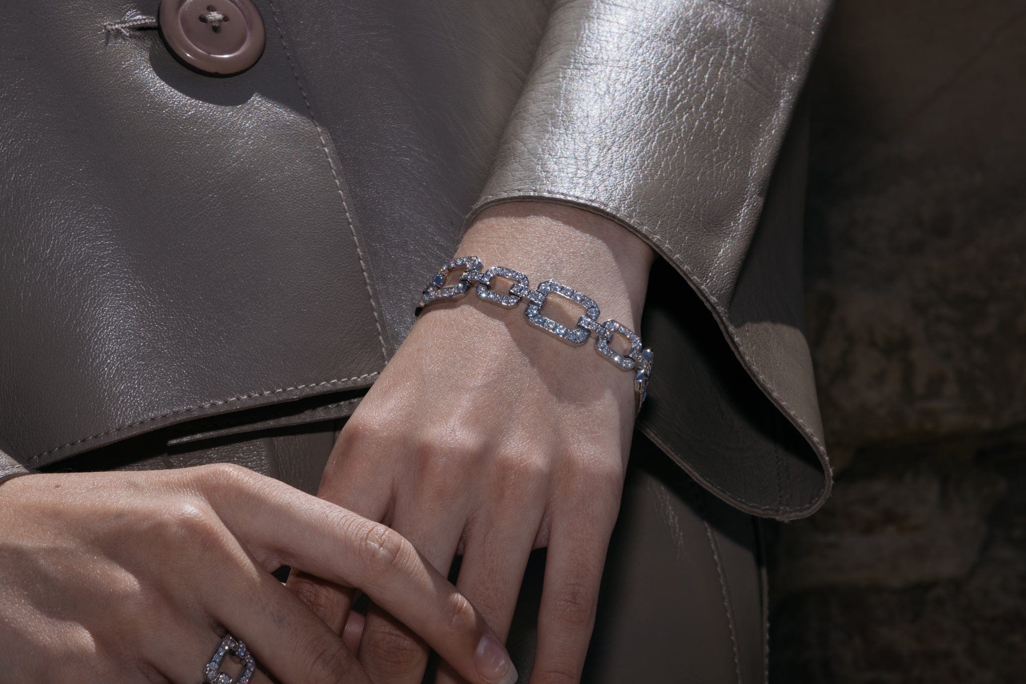 close up image of A Diamond Chain Link Bracelet made of 18ct white gold, and matching ring featuring multiple round brilliant cut diamonds.