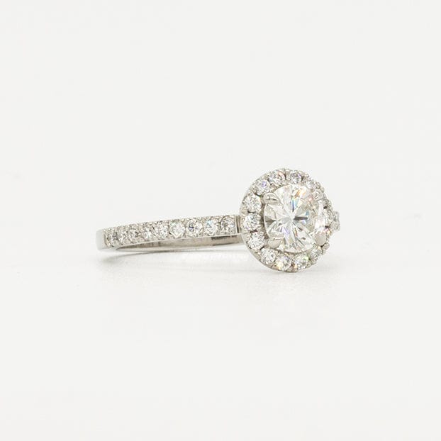 Round diamond platinum ring with a halo of pave diamonds. Also features round pave diamonds down the band
