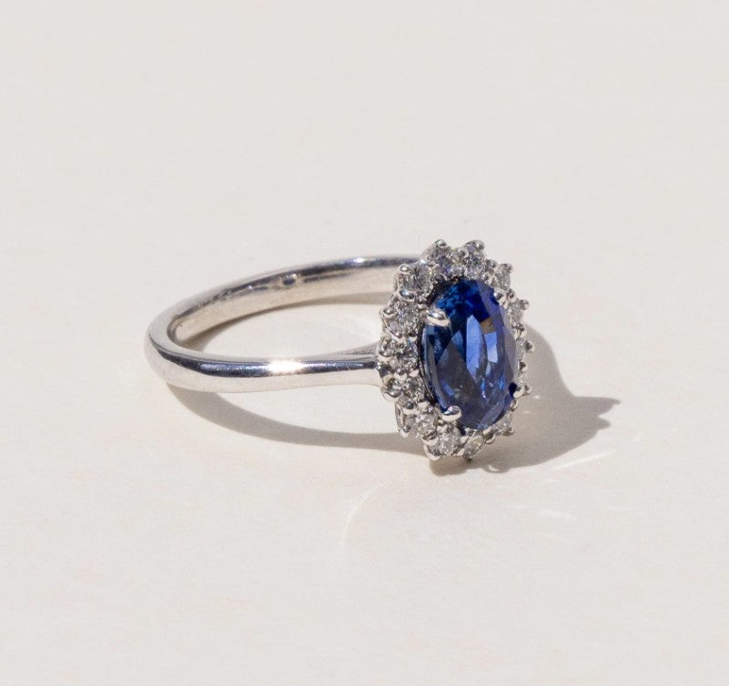 Blue sapphire engagement ring with a halo of diamonds. Made in Auckland, New Zealand by an award-winning team. 