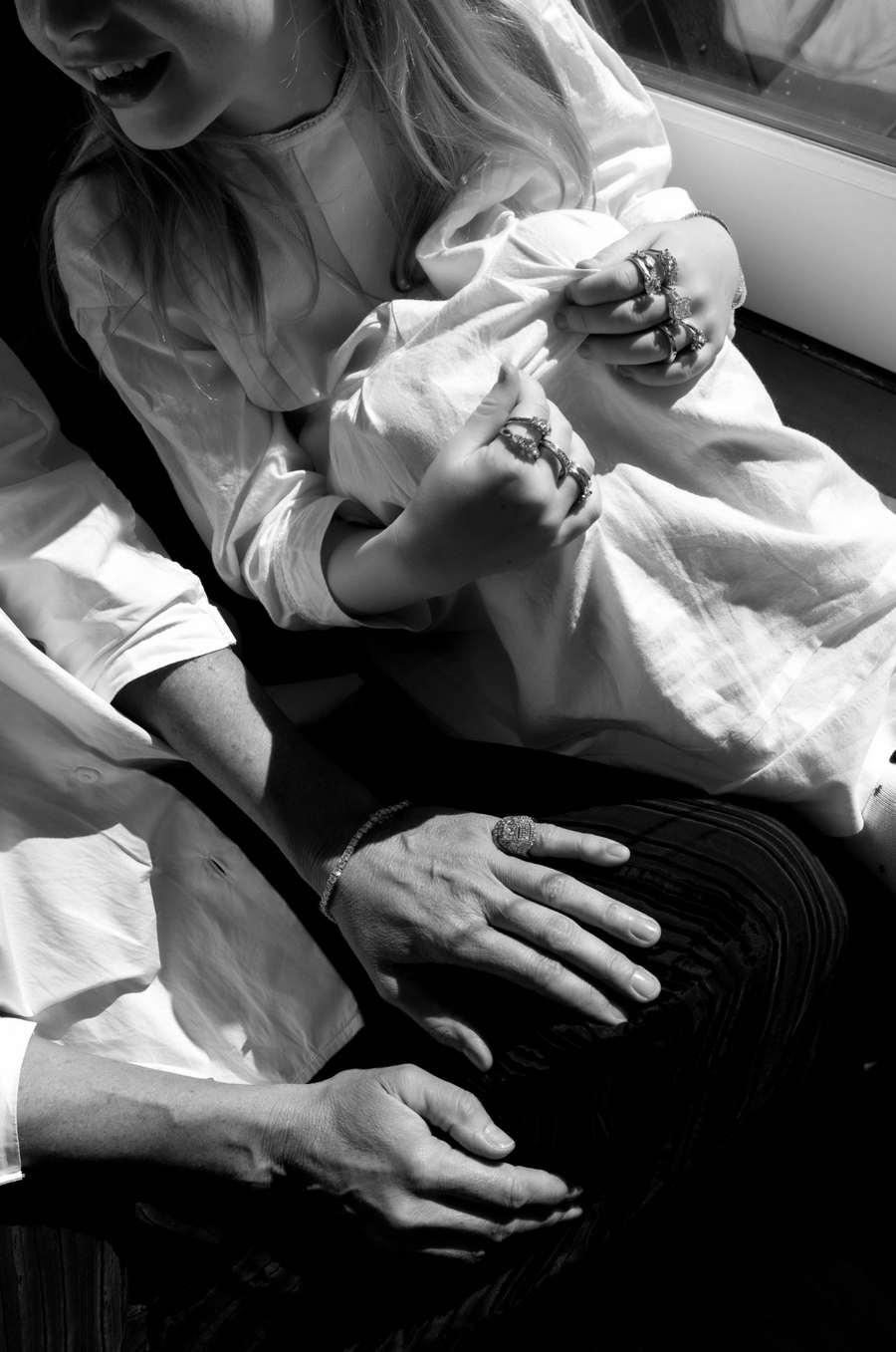 Cropped image of a young girl with older person wearing a large amount of rings and jewellery 