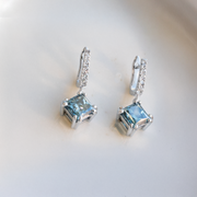 huggie earrings with a blue diamond drop. hand crafted by our master jewellers in our workshop in auckland, new zealand 