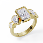 Yellow Gold ring with a central emerald-cut diamond flanked by two oval diamonds. Bezel set in a low profile. Angled view