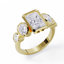 Yellow Gold ring with a central emerald-cut diamond flanked by two oval diamonds. Bezel set in a low profile. Angled view