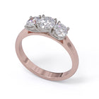 A three-stone diamond ring with a rose gold band and platinum setting for the diamonds.