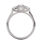 A three-stone diamond ring with a white gold or platinum band and platinum setting for the diamonds.