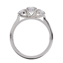 A three-stone diamond ring with a white gold or platinum band and platinum setting for the diamonds.
