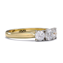 A three-stone diamond ring with a yellow gold band and platinum setting for the diamonds.