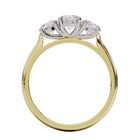 A three-stone diamond ring with a yellow gold band and platinum setting for the diamonds.