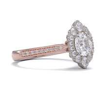 A gold diamond ring with a large round central diamond surrounded by a halo of smaller round diamonds. Set in platinum on a rose gold band with pave down on the band, displayed against a white background.