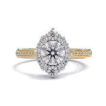 A gold diamond ring with a large round central diamond surrounded by a halo of smaller round diamonds. Set in platinum on a yellow gold band with pave down on the band, displayed against a white background.