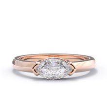 Rose gold east west marquise ring with a large diamond on a white background