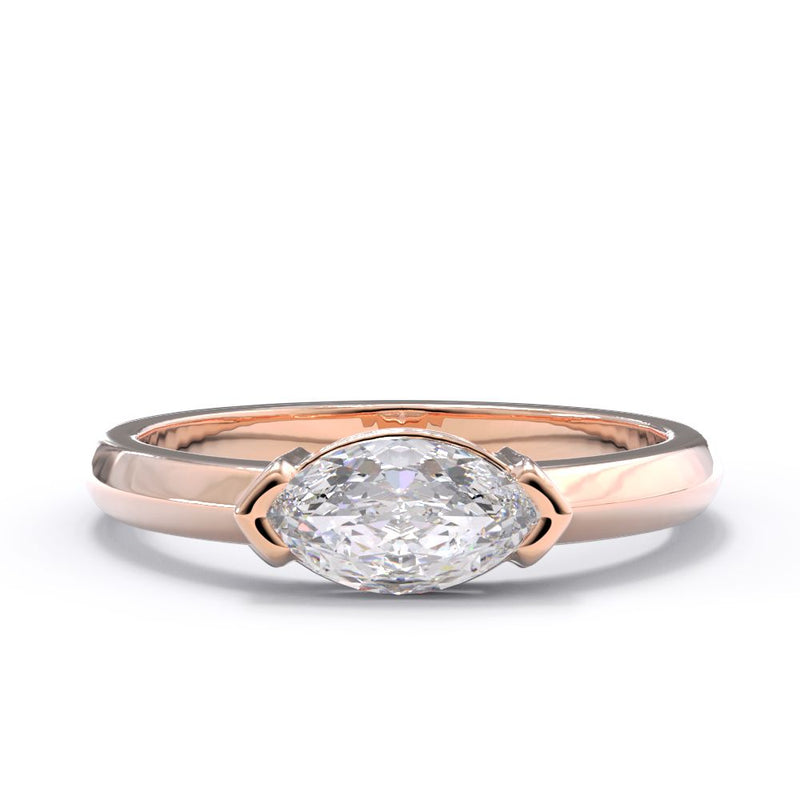 Rose gold east west marquise ring with a large diamond on a white background
