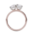 A solitaire diamond Toi et Moi style ring with a rose gold band set in a platinum setting.