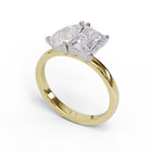 A solitaire diamond Toi et Moi style ring with a yellow gold band set in a platinum setting.