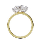 A solitaire diamond Toi et Moi style ring with a yellow gold band set in a platinum setting.