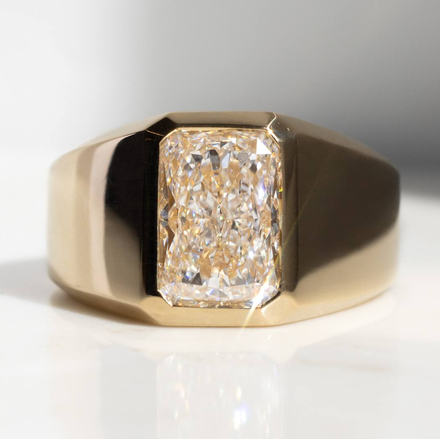 Gold ring with a large diamond on a white background