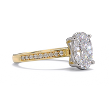 Gold ring with a large diamond and smaller diamonds on the band against a white background
