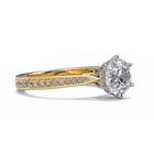Gold ring with a large diamond and smaller diamonds on the band against a white background
