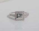 Front view of a diamond engagement ring featuring a halo of diamonds around the centre stone and rows of diamonds along the band.