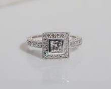 Front view of a diamond engagement ring featuring a halo of diamonds around the centre stone and rows of diamonds along the band.