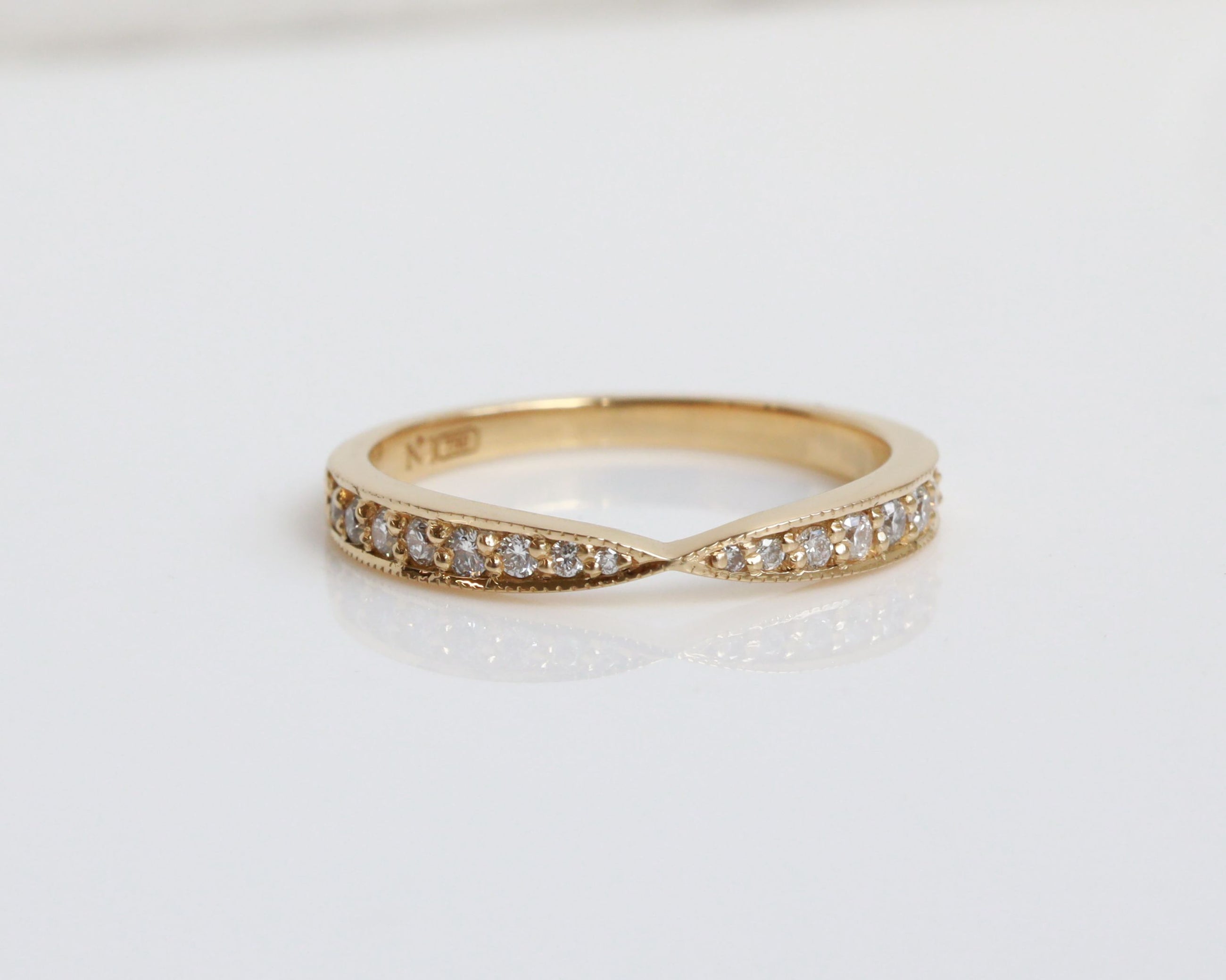 Gold ring with small diamonds on a light background