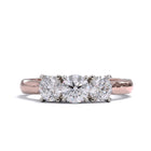 A three-stone diamond ring with a rose gold band and platinum setting for the diamonds.