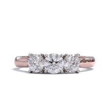 A three-stone diamond ring with a rose gold band and platinum setting for the diamonds.