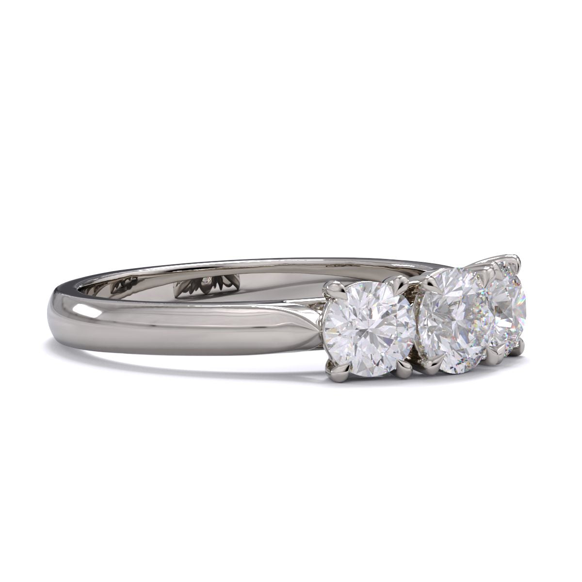 A three-stone diamond ring with a white gold or platinum band and platinum setting for the diamonds.