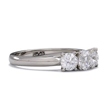A three-stone diamond ring with a white gold or platinum band and platinum setting for the diamonds.