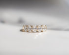 Gold ring with diamonds on a light gray background