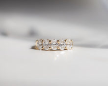 Gold ring with diamonds on a light gray background