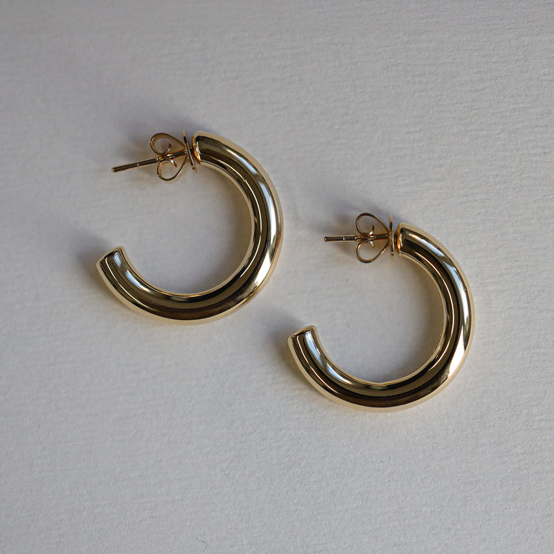 Gold hoop earrings on a light gray background