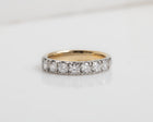 Gold ring with diamonds on a light gray background