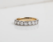 Gold ring with diamonds on a light gray background